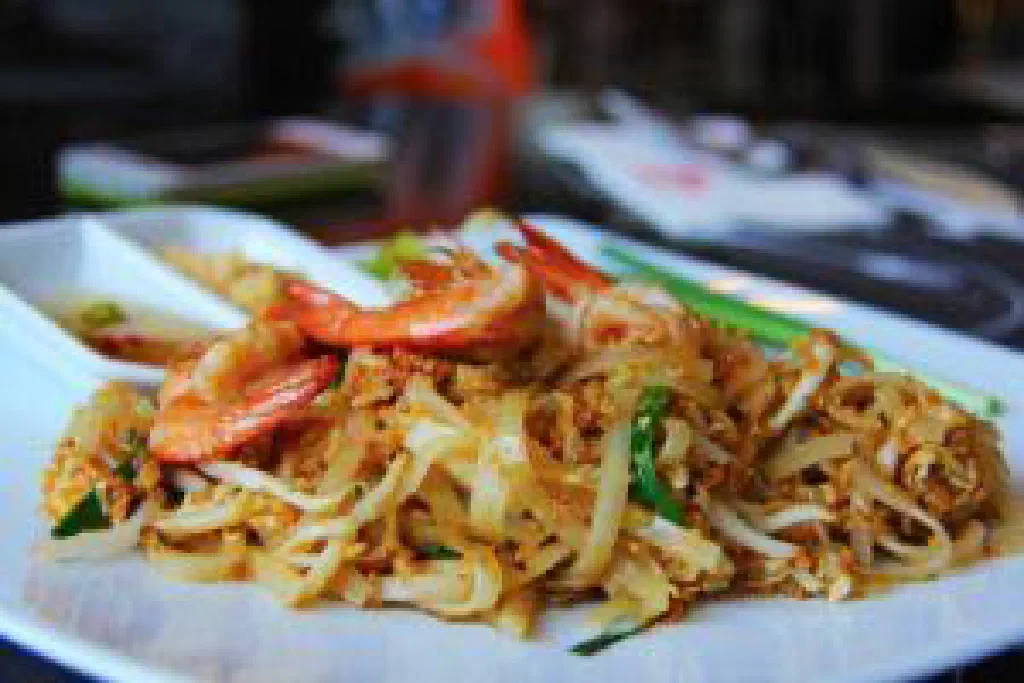 Pad Thai stir-fried rice noodles with prawns, spring onions and a lime wedge