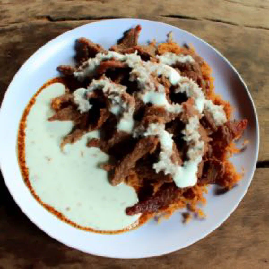 Pulu kafe tender meat braised in creamy coconut milk, garnished with fresh herbs