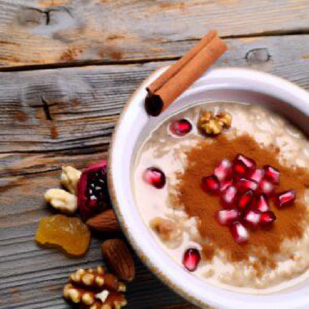 Bowl of Aşure topped with pomegranate seeds and chopped nuts