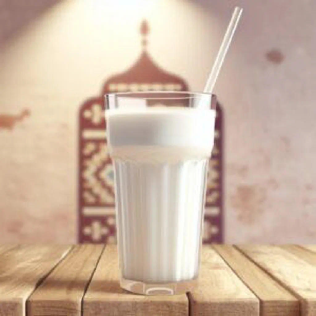 A frothy glass of ayran garnished with fresh mint leaves