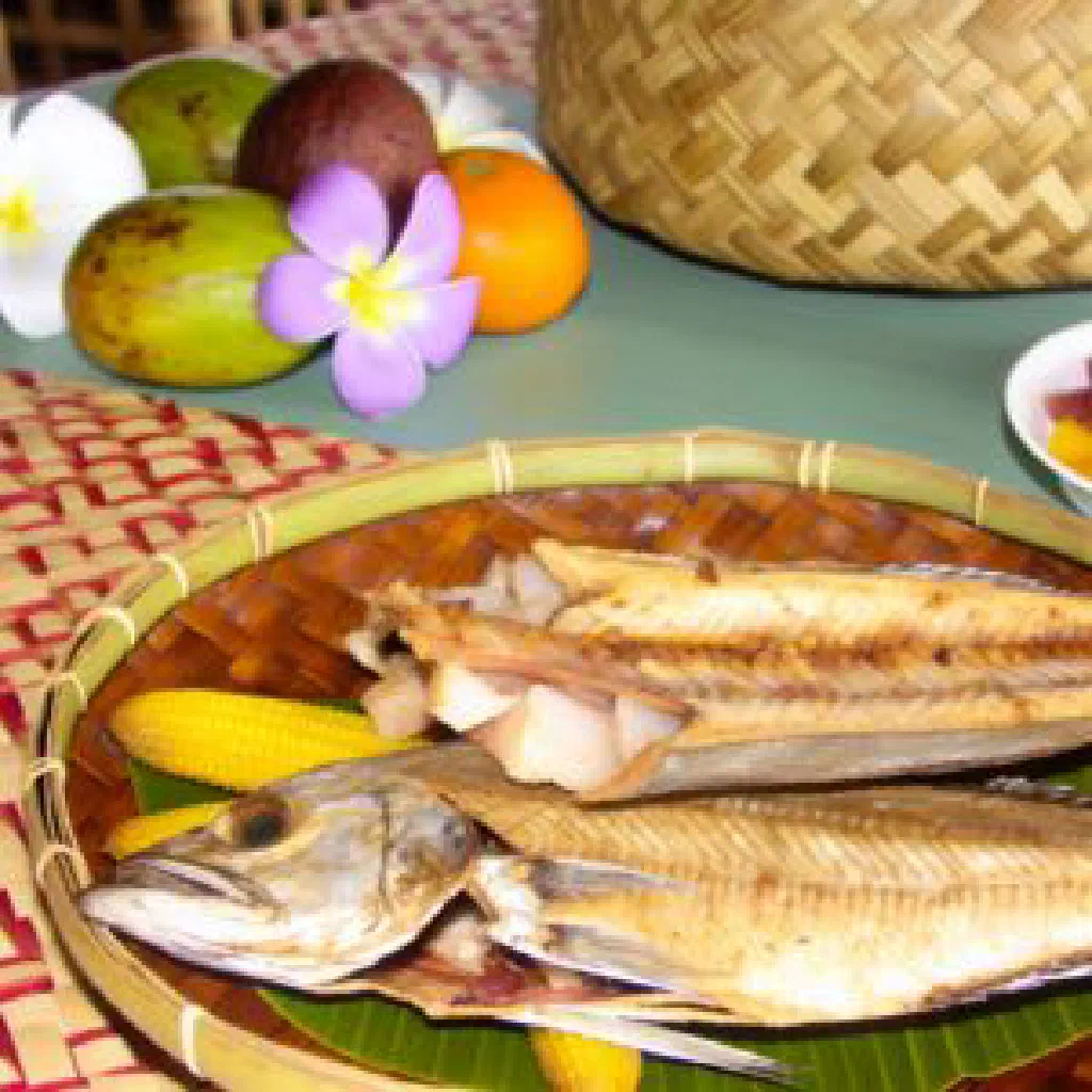 Whole smoked reef fish with lime wedges and fresh herbs
