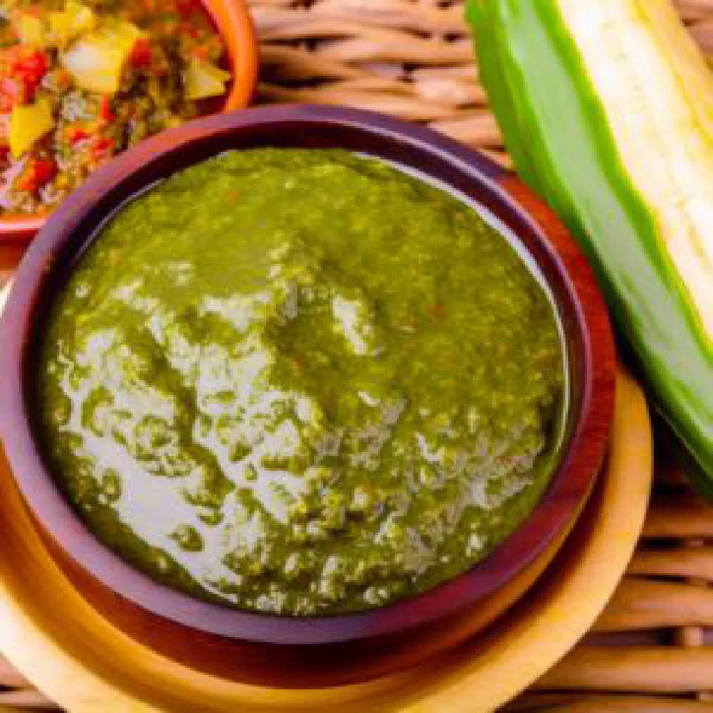 Creamy green nakati sauce in a bowl with peanut garnish