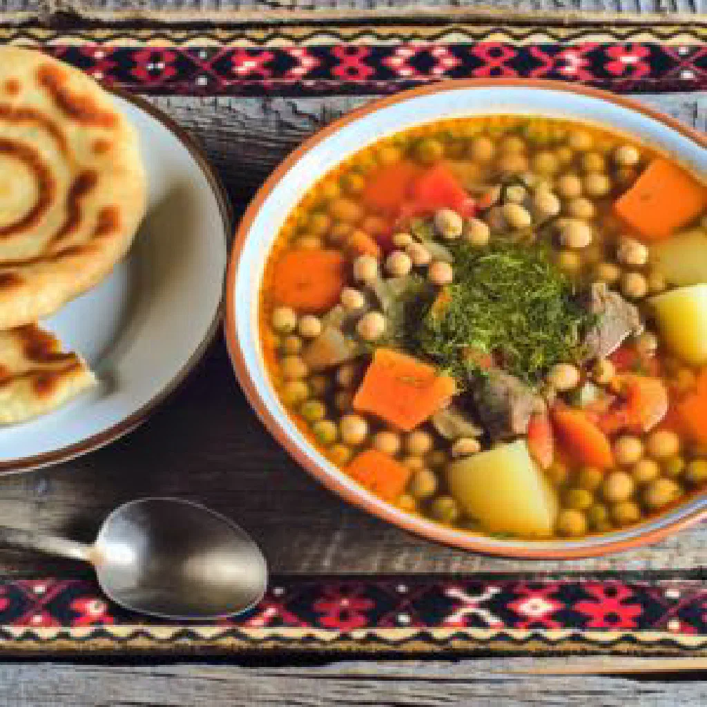 Bowl of Uzbek mashkhurda with rice, lamb and carrots, garnished with fresh herbs