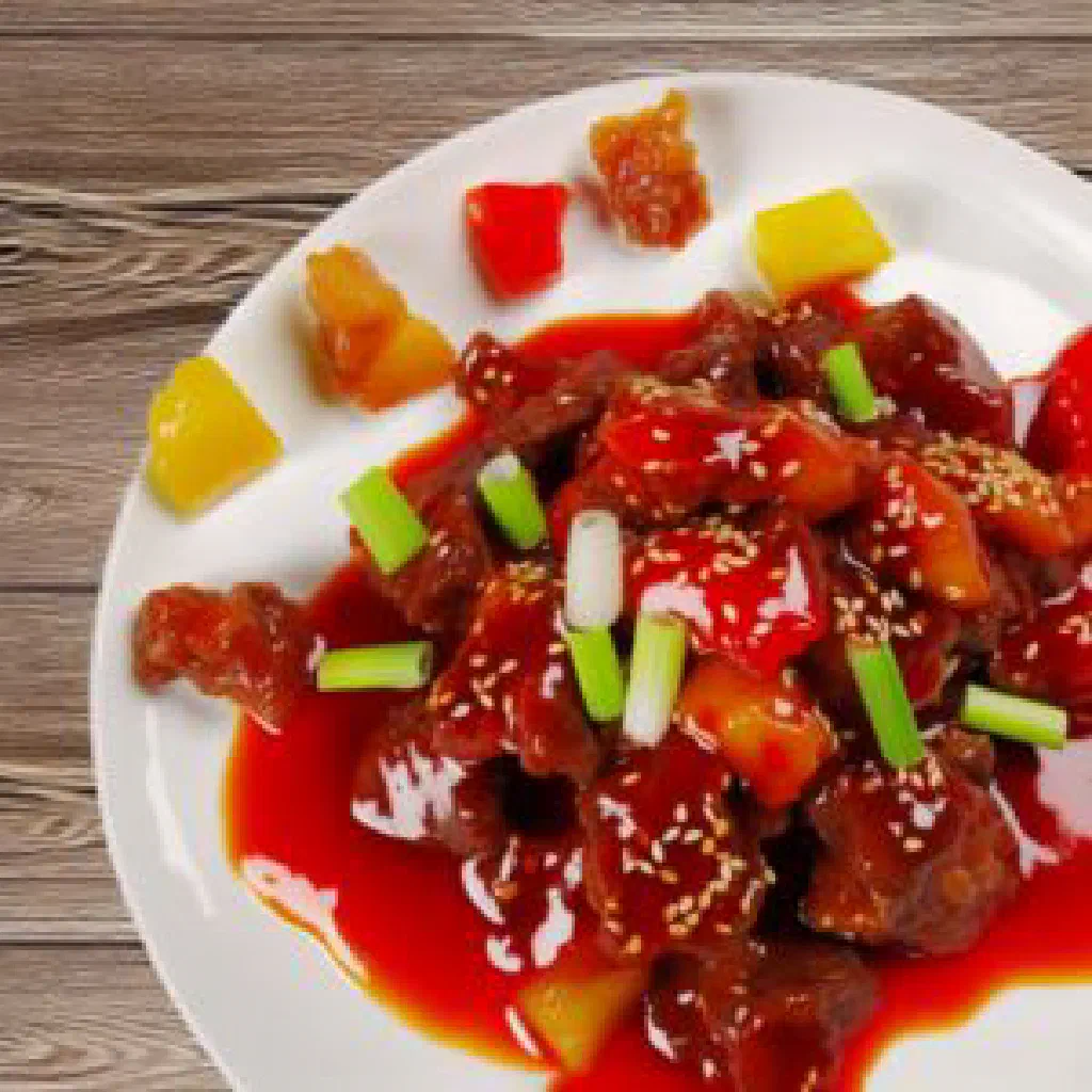 Sliced Venezuelan asado negro beef in dark sweet-and-sour sauce with rice