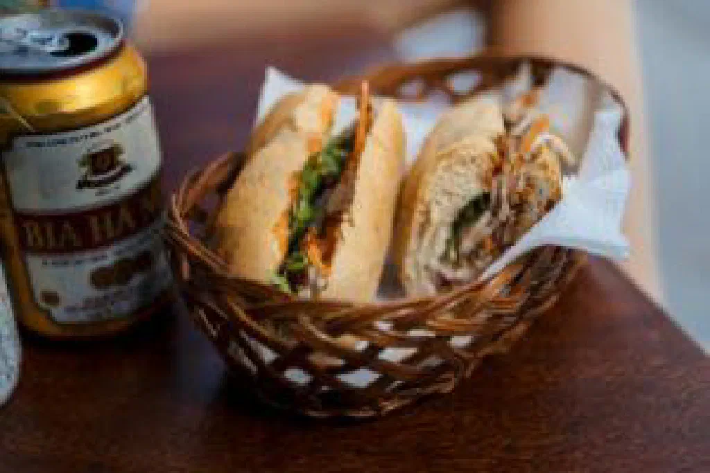 Vietnamese banh mi baguette filled with pork, pickled vegetables and fresh herbs