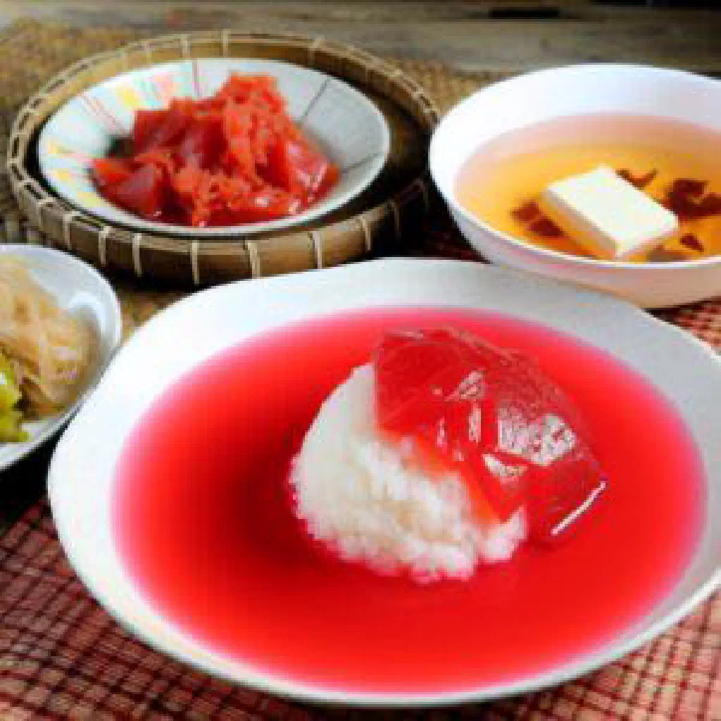 Bright red xôi gấc sticky rice moulded into a dome and sprinkled with sesame seeds