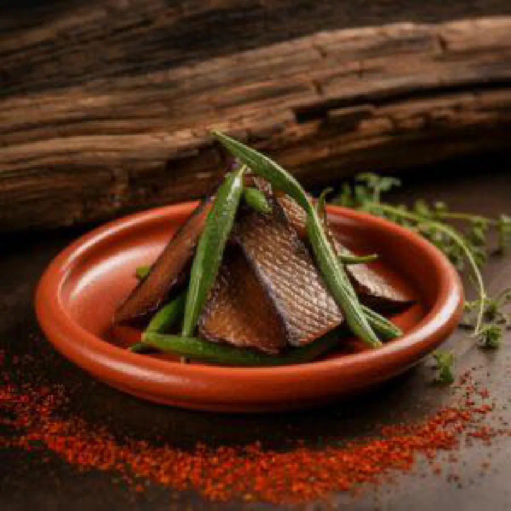 Grilled smoked fish fillet served with sautéed okra and lemon wedges
